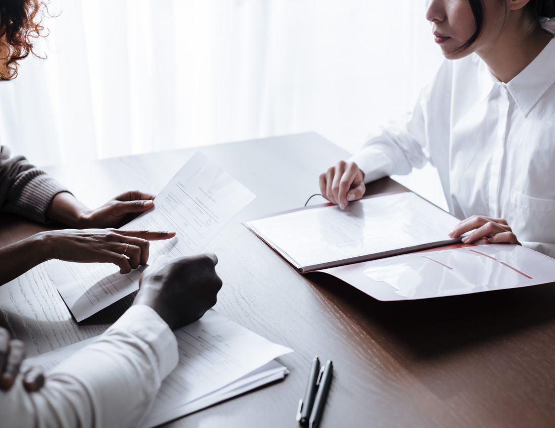 Illustrative stock photo: People reviewing documents at a table.