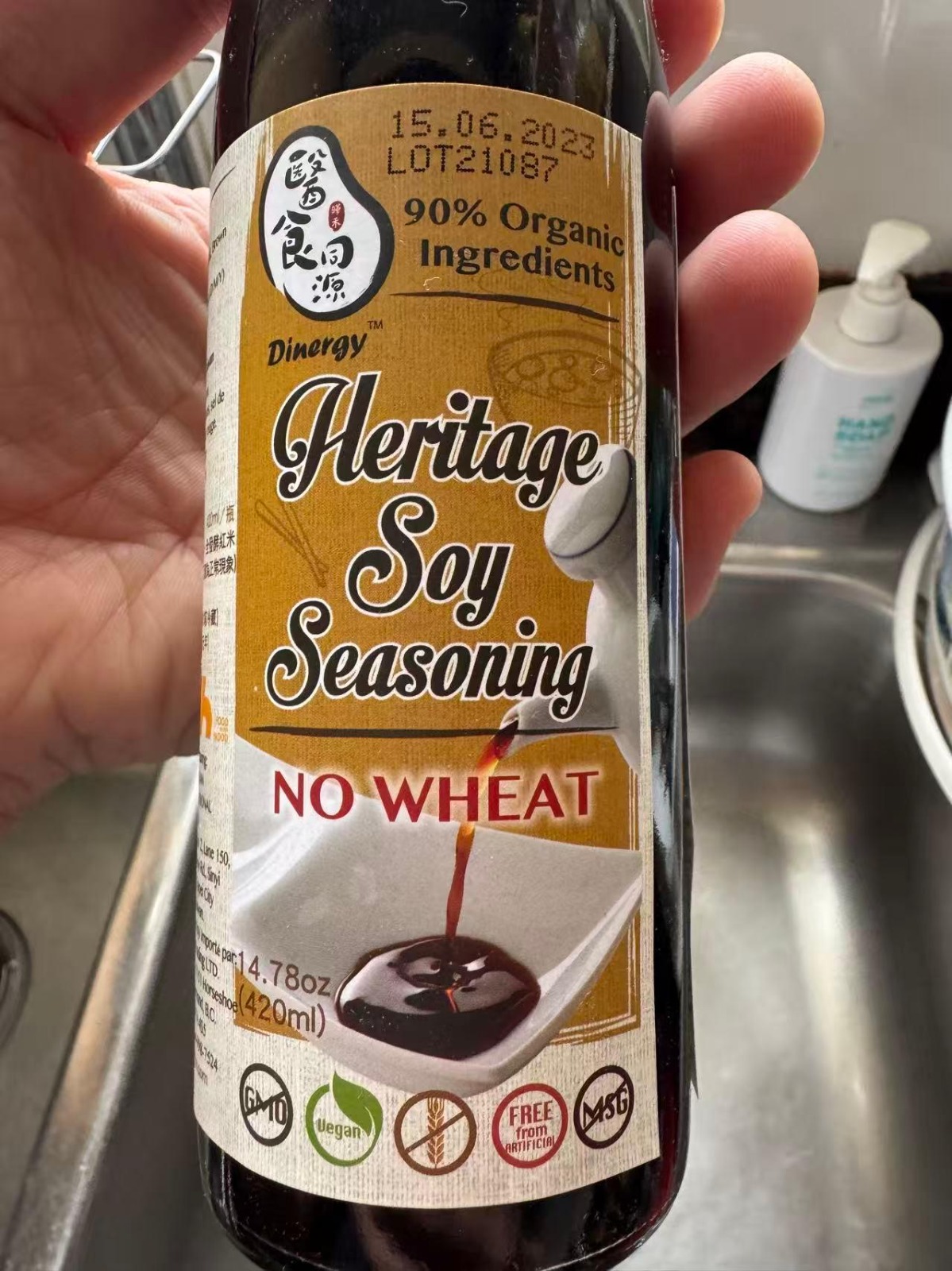 Handheld soy seasoning bottle showing the English product label